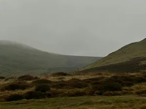 Misty hills with dry grass in the foreground. jigsaw puzzle