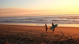 two surfers walking on sand going on water jigsaw puzzle