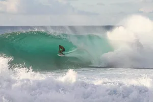 man riding surfboard under sea wave during daytime jigsaw puzzle