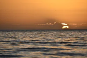 Beautiful sunset over ocean with orange and golden hues, creating a serene and calming atmosphere. jigsaw puzzle