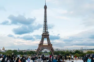 Iconic view of the Eiffel Tower in Paris surrounded by tourists on a cloudy day. jigsaw puzzle