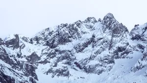 A breathtaking view of snow-covered mountain peaks under a clear winter sky, perfect for nature enthusiasts. jigsaw puzzle