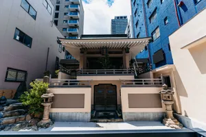 A serene Japanese temple courtyard framed by modern urban buildings, showcasing architectural contrast. jigsaw puzzle