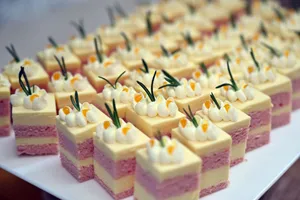 Close-up of assorted mini cream cakes with icing and toppings on a platter. jigsaw puzzle