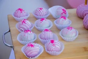 Eye-catching purple cake balls with sprinkles displayed on a wooden tray, ideal for parties. jigsaw puzzle