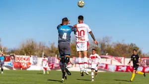 Soccer players in uniforms jumping to head the ball during an outdoor match on a sunny day. jigsaw puzzle
