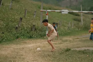 Young boys enjoying a game of soccer on a rural grassy field. jigsaw puzzle