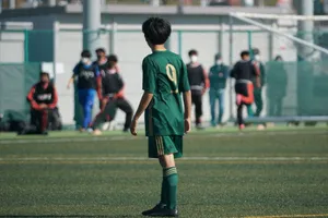 Youth soccer player in green jersey on football field during match. jigsaw puzzle