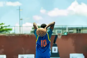 A young athlete prepares for a basketball shot on an outdoor court in Nigeria. jigsaw puzzle