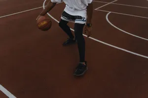 Dynamic shot of a basketball player dribbling on an outdoor court, showcasing athleticism. jigsaw puzzle