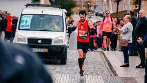 Male athlete running in urban marathon with supportive crowd. jigsaw puzzle