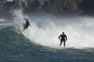 Two surfers skillfully ride big ocean waves, showcasing athleticism and thrill. jigsaw puzzle