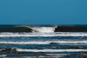 A lone surfer catching a wave against a bright blue sky, displaying skill and adventure. jigsaw puzzle