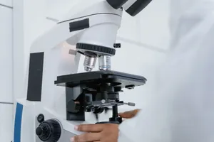 Detailed view of a scientist operating a microscope in a laboratory setting. jigsaw puzzle