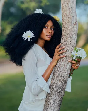Woman with flowers in hair embraces tree, exuding natural beauty and elegance. jigsaw puzzle