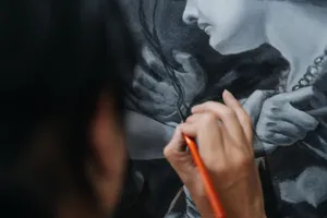 Close-up of artist carefully painting a detailed portrait using fine brushes. jigsaw puzzle
