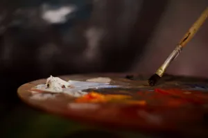 Close-up of an artist's palette with vibrant paints and a brush for creative expression. jigsaw puzzle