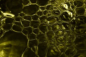 Macro shot of abstract yellow bubbles in liquid forming a honeycomb pattern, ideal for creative backgrounds. jigsaw puzzle