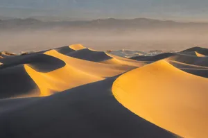 a group of sand dunes with mountains in the background jigsaw puzzle
