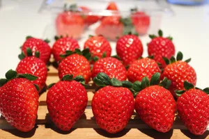 a group of strawberries sitting on top of a wooden cutting board jigsaw puzzle