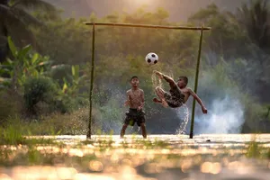 2 boys playing soccer on water during daytime jigsaw puzzle