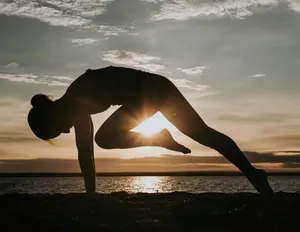 a woman doing a yoga pose in front of the sun jigsaw puzzle