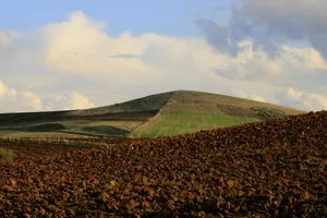 Serene landscape of rolling hills and fields in Algeria under a dramatic sky. jigsaw puzzle