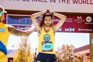 Exhausted marathon runner crossing the finish line triumphantly under sunny skies. jigsaw puzzle