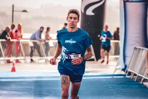 Focused runner finishing a marathon on a sunny day, showcasing energy and endurance. jigsaw puzzle
