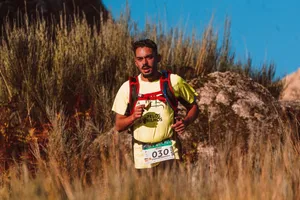 A man participates in a trail marathon, running through rugged terrain in bright sunlight. jigsaw puzzle