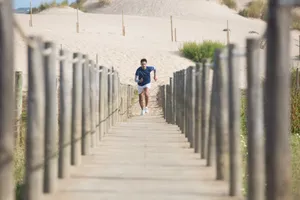 Man in activewear running on a wooden boardwalk at a scenic beach. Perfect for fitness and lifestyle themes. jigsaw puzzle