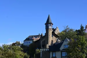 Scenic view of the historic Lahneck Castle in Lahnstein, surrounded by lush trees under a clear blue sky. jigsaw puzzle