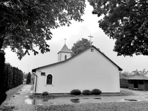 A serene black and white photo of a rural chapel amidst trees and nature. jigsaw puzzle