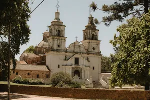 A picturesque historic church in Córdoba, Argentina, surrounded by lush greenery. jigsaw puzzle