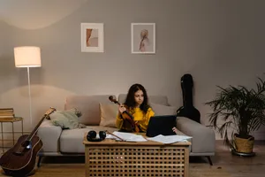 Teen girl playing violin and using a tablet in a warm, cozy living room setting. jigsaw puzzle