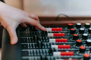 Hand adjusting mixer controls in a sound studio, showcasing precision and audio engineering. jigsaw puzzle