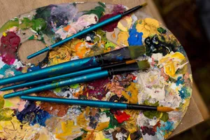 Vibrant painter's palette with colorful mixed paints and brushes for creative art projects. jigsaw puzzle