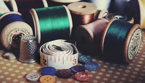 Close-up of vintage sewing essentials including threads, buttons, thimble, and measuring tape. jigsaw puzzle