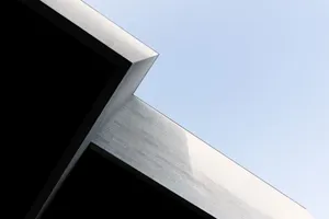 Minimalist view of a geometric building corner against a clear sky in Vilnius. jigsaw puzzle