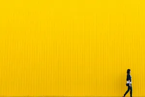 woman wearing black top standing near yellow wall jigsaw puzzle