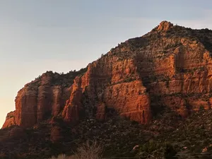 Red rock mountains glow under a clear sky at sunset. jigsaw puzzle