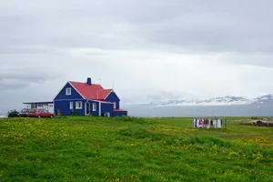 red and white house on green grass field under white clouds during daytime jigsaw puzzle