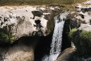 A refreshing waterfall cascading over rocks in a serene natural setting, ideal for nature photography. jigsaw puzzle