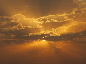 Capture of a golden sunset with dramatic clouds and sun rays illuminating the sky. jigsaw puzzle