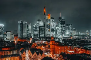 A stunning night view of Frankfurt's skyline featuring illuminated skyscrapers and historic buildings. jigsaw puzzle