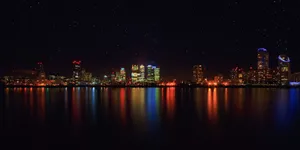 City skyline at night with shimmering water reflections and starry sky. jigsaw puzzle