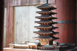 Detailed miniature model of a traditional wooden pagoda displayed indoors with soft lighting. jigsaw puzzle