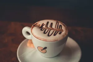 Close-up of a beautifully decorated latte with chocolate art in a ceramic cup on a saucer. jigsaw puzzle