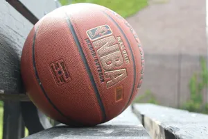 A detailed image showcasing a basketball resting on a park bench, highlighting texture and outdoor setting. jigsaw puzzle