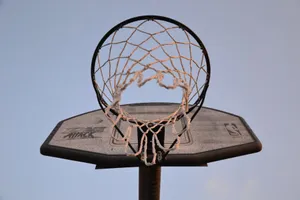 Close-up view of a basketball hoop and net against a clear sky, ideal for sports and leisure themes. jigsaw puzzle